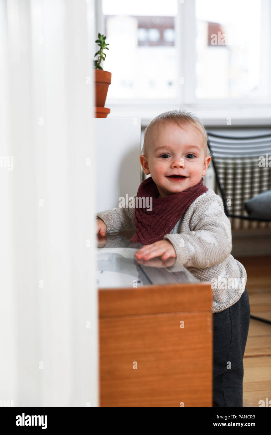 Baby Mädchen erkunden Wohnzimmer, laufen lernen Stockfoto