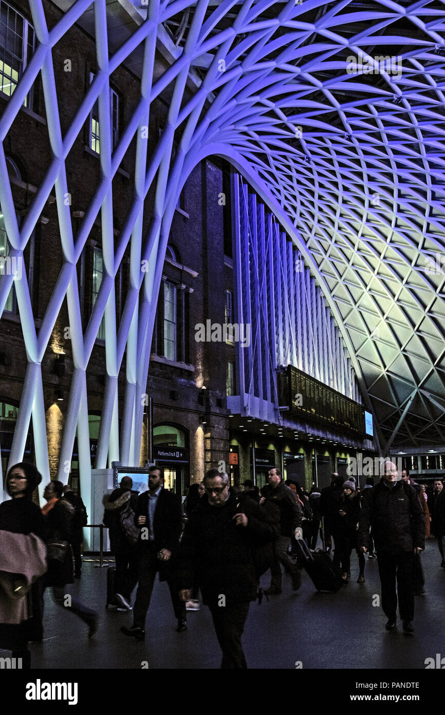 Die Menschen warten für Züge und Spaziergang in der Kings Cross Concourse, unter dem blauen, moderne Dach am Bahnhof Kings Cross, London, England, UK. Porträt Stockfoto