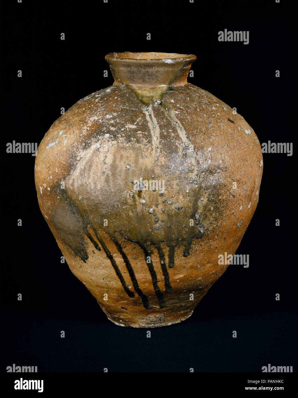 Storage Jar. Kultur: Japan. Abmessungen: H 18 cm. (46,7 cm); Durchm. 15 1/2 in. (39,4 cm). Datum: 14.-15. Jahrhundert. Diese mittelalterliche Storage jar, mit seinen zerklüfteten Oberfläche und massiven Form, wurde in mehreren Stufen mit Spulen von Lehm gebaut. Seine überzeugende Darstellung spiegelt das Drama seiner Schöpfung in einer großen Tunnel Brennofen, wo Hartholz Esche auf seine geschmolzene Oberfläche angesiedelt. Museum: Metropolitan Museum of Art, New York, USA. Stockfoto