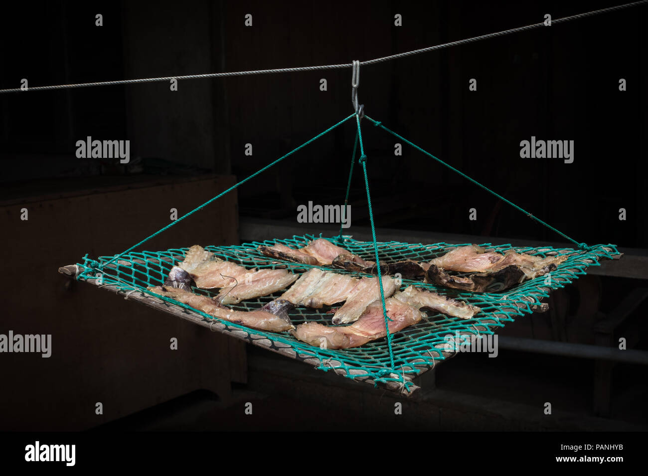 Fisch (Tilapia) hängen in einem Gerahmten net in der Sonne zu trocknen. Stockfoto
