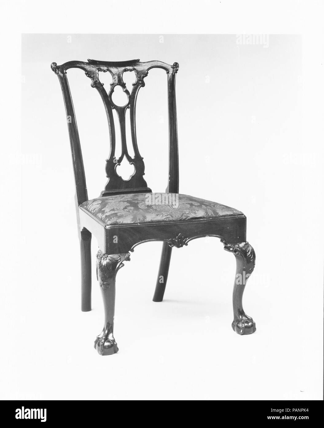 Side Chair. Kultur: American. Abmessungen: 39 x 21 1/2 x 21 1/2 in. (99,1 x 54,6 x 54,6 cm). Datum: 1760-90. Dies ist ein Beispiel für das Kleeblatt - durchbohrt - splat Stuhl, die vor allem in Philadelphia populär war. Außer den Blättern - wie zentralen Teil der Kammschiene, das Design der gesamten Rückseite wurde Zeile für Zeile von der Platte 10 der ersten Ausgabe von Thomas Chippendale's 'Gentleman und Cabinet-Maker Direktor' (1754). Museum: Metropolitan Museum of Art, New York, USA. Stockfoto