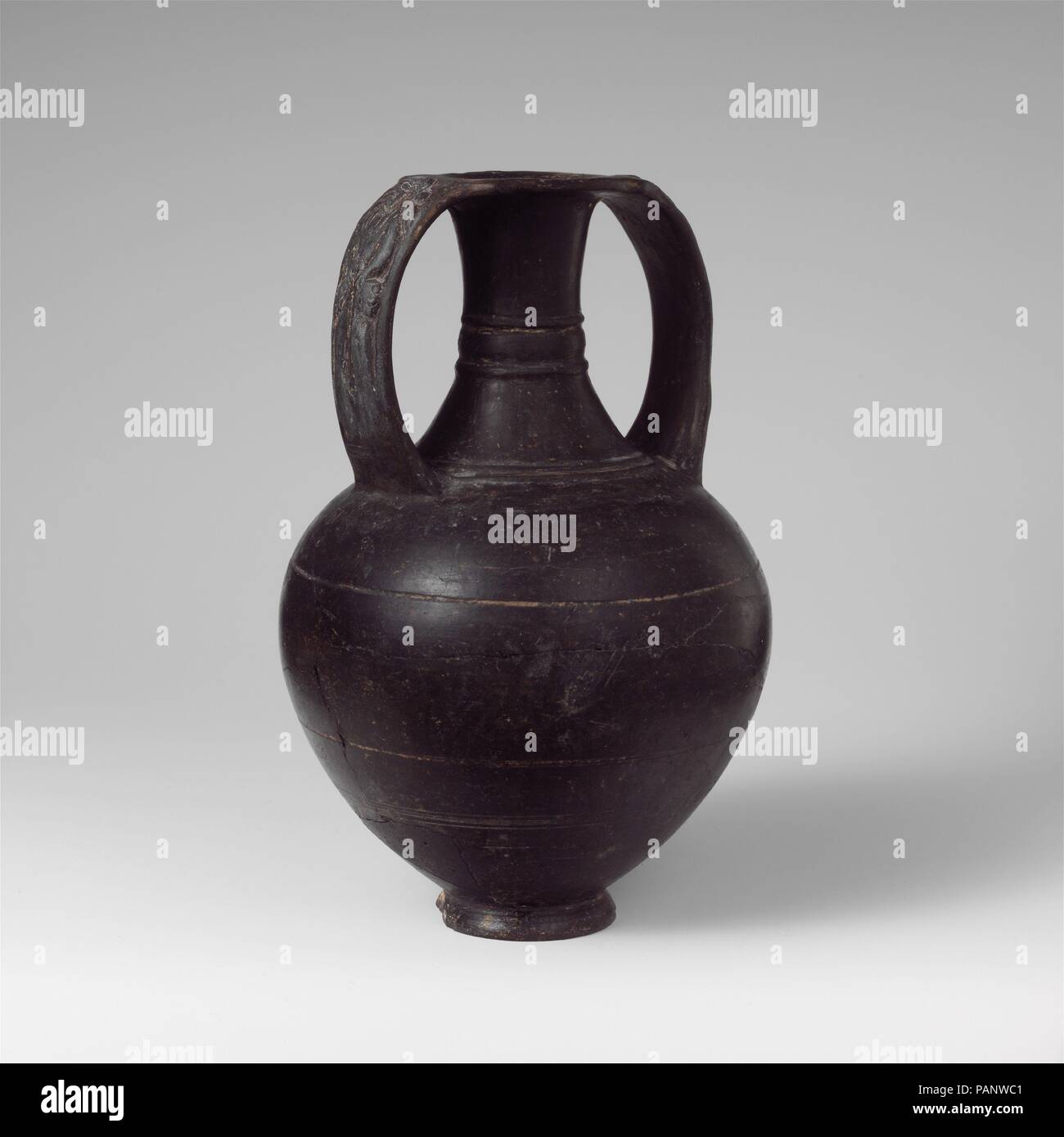 Terrakotta Nicosthenic Neck-Amphora. Kultur: Etrusker. Abmessungen: 7 15/16 in. (20,2 cm). Datum: 6. Jahrhundert v. Chr.. Auf der in der Entlastung Griffe, weibliche Figur mit zwei Katzen den Kontrast zwischen dem schmalen Hals und den vollen Körper, der dünnen Griffen, und die glänzende Oberfläche geben diesem Nicosthenic Neck-Amphora eine manierierte Charakter. Museum: Metropolitan Museum of Art, New York, USA. Stockfoto