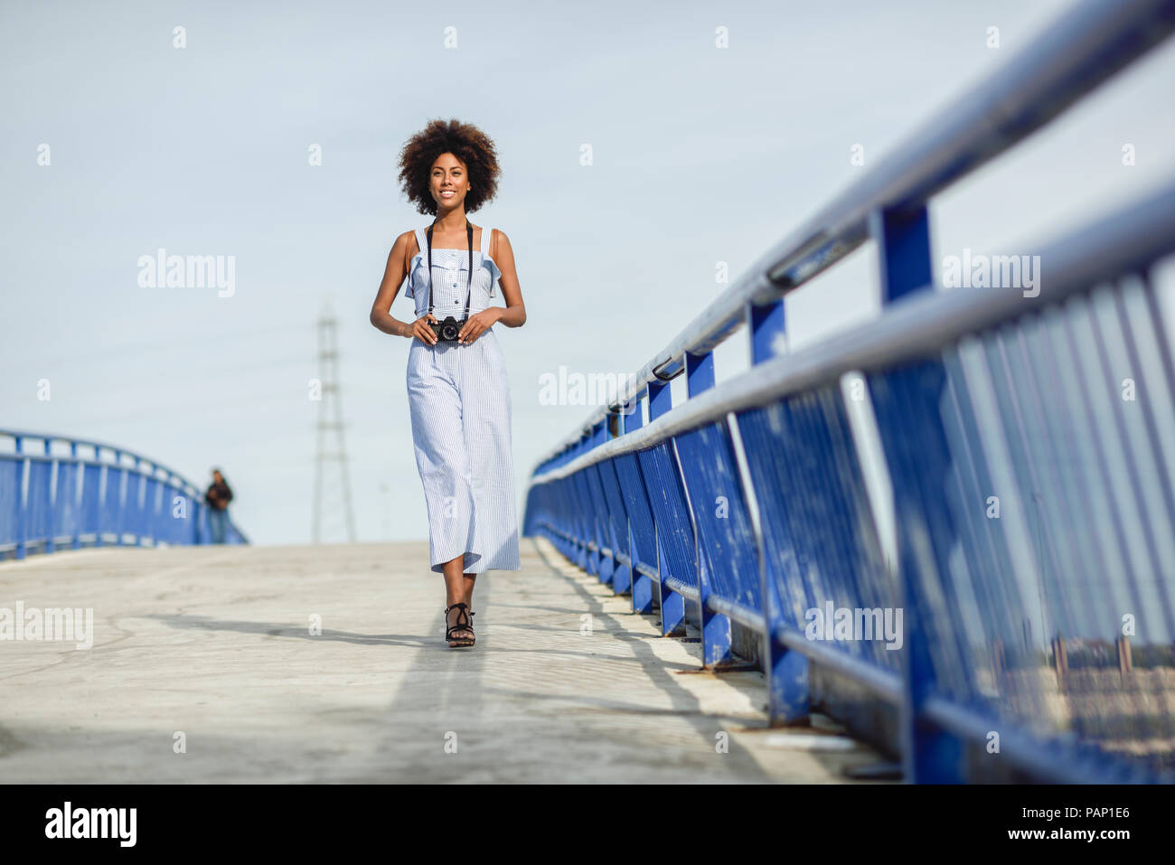 Inhalt junge Frau mit Kamera zu Fuß auf einer Brücke Stockfoto