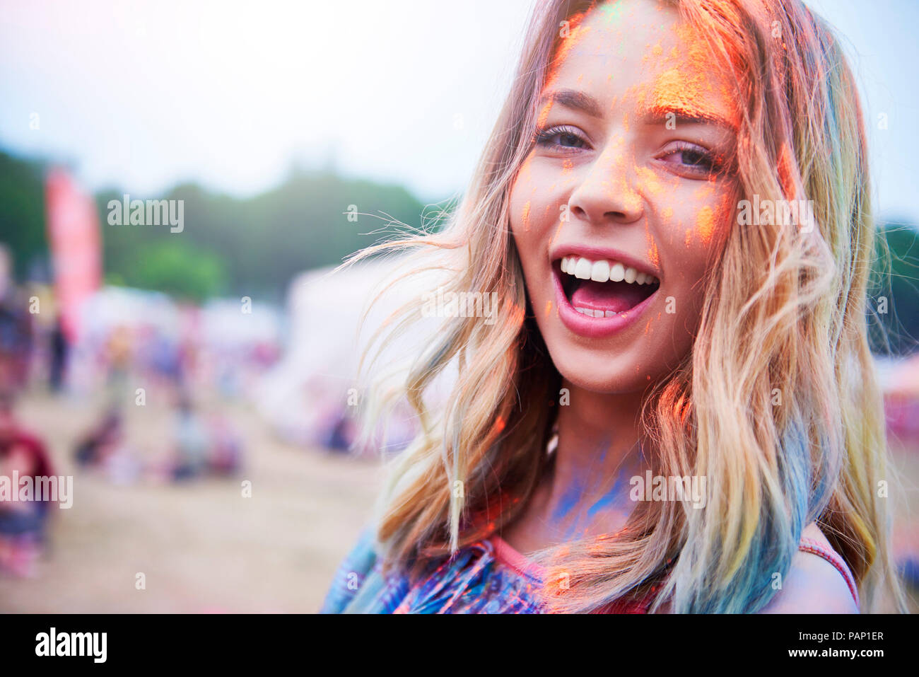 Porträt der glückliche junge Frau, die Spaß mit bunten Pulver Stockfoto