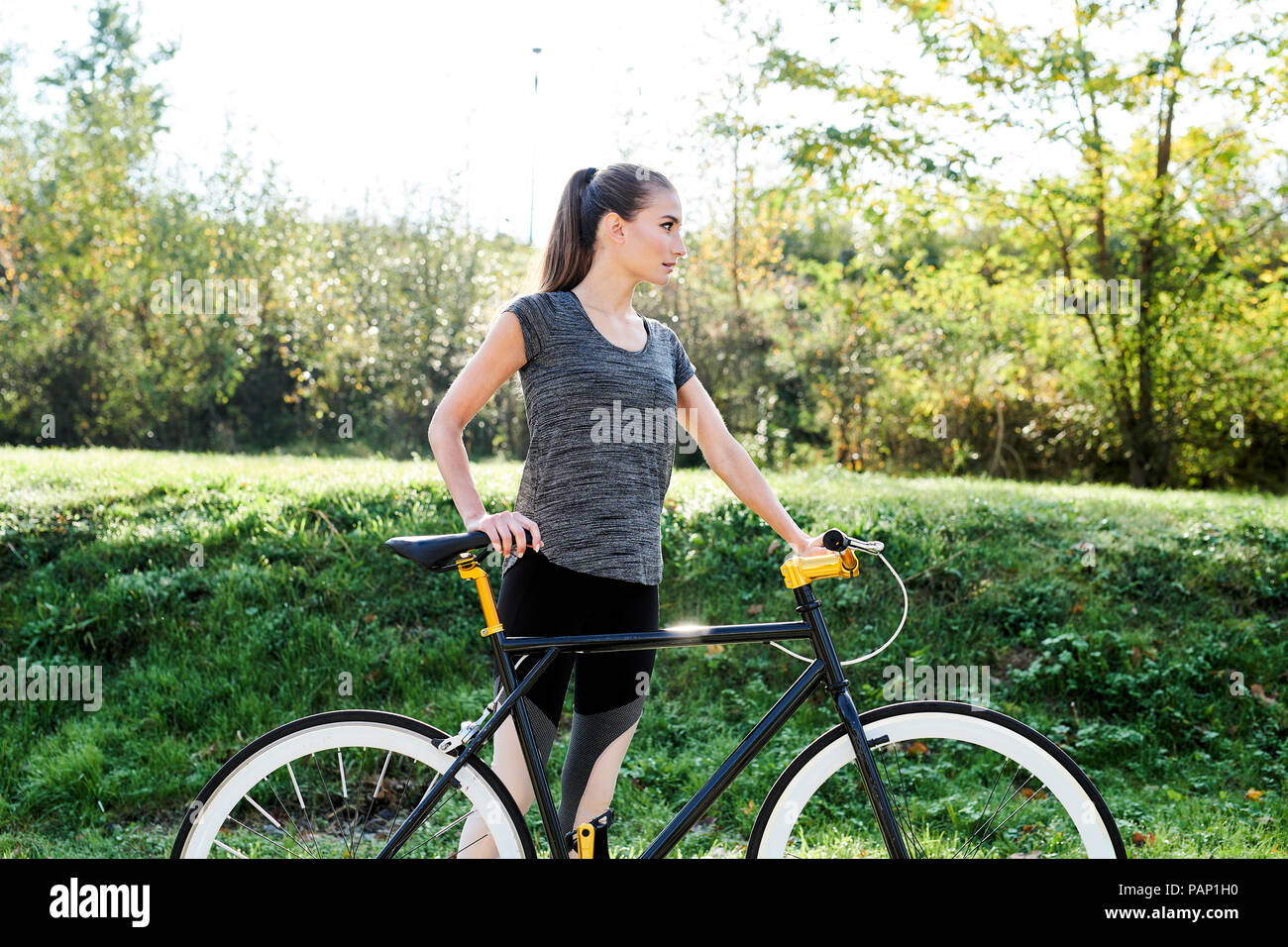 Sportliche junge Frau mit dem Fahrrad in der Natur Stockfoto