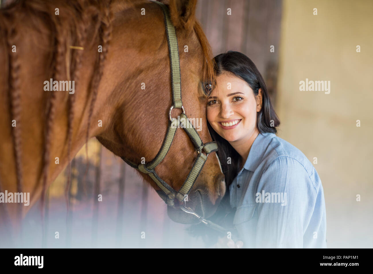 Porträt der lächelnde Frau mit einem Pferd auf einem Bauernhof Stockfoto