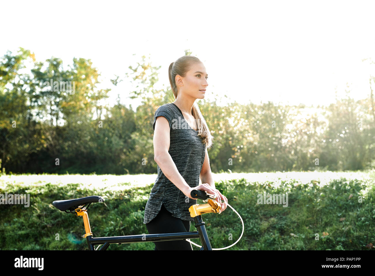 Sportliche junge Frau mit dem Fahrrad in der Natur Stockfoto