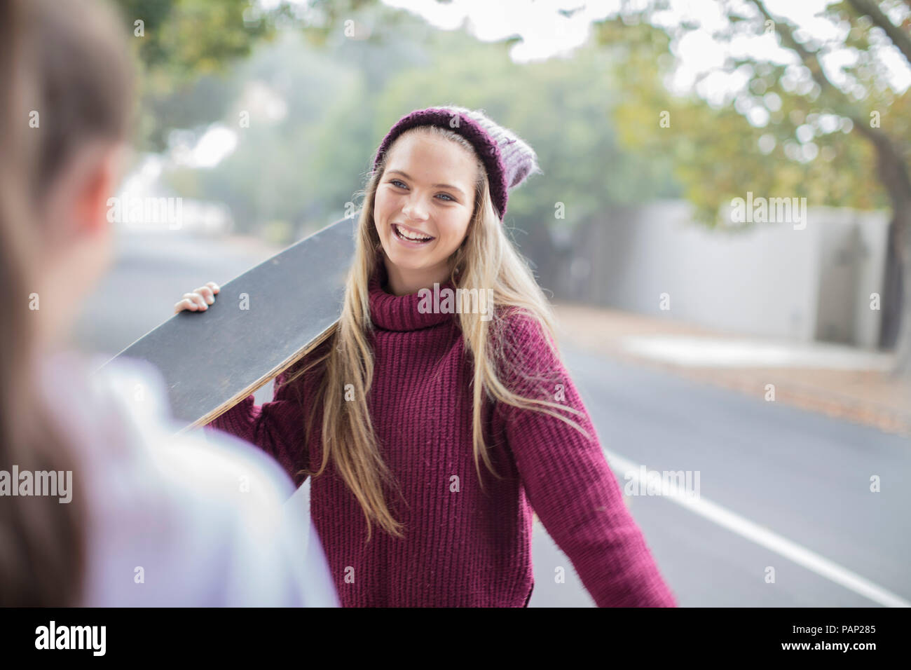 Lächelnd Jugendmädchen Holding skateboard Treffen mit Freund Stockfoto