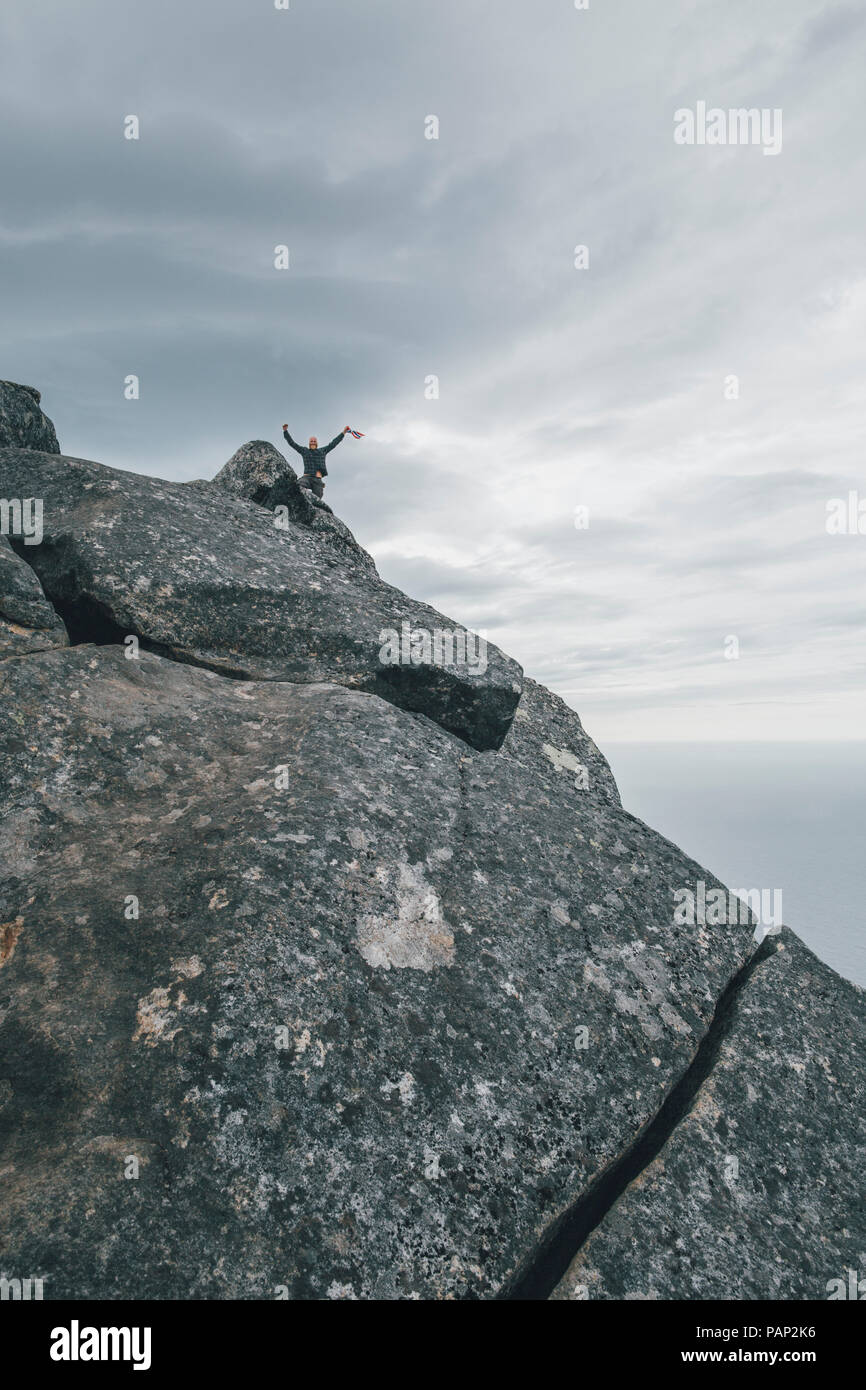 Norwegen, Lofoten, Moskenesoy, junger Mann winkte aus Hermannsdalstinden Stockfoto