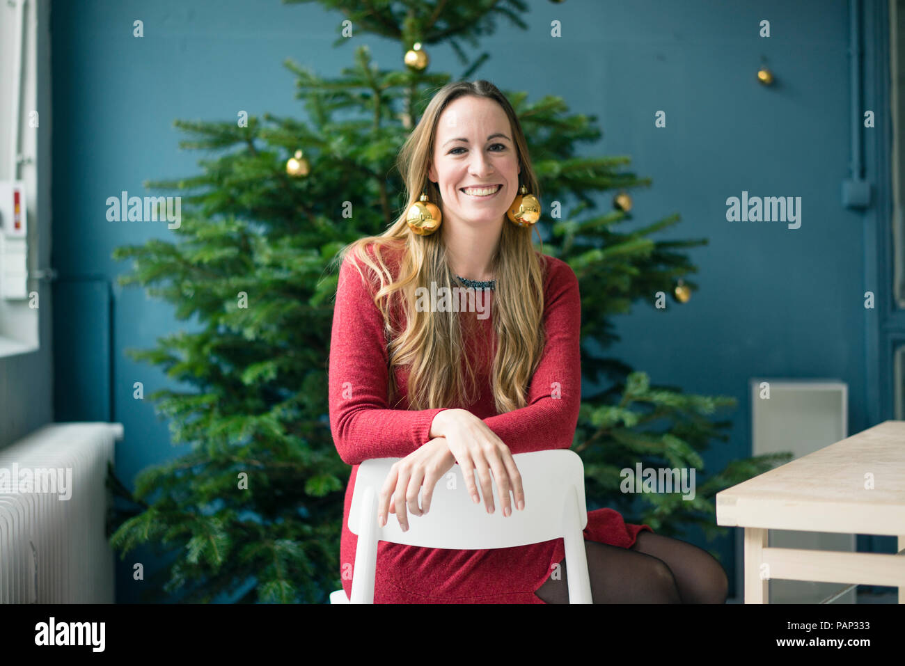 Portrait lachende Frau mit goldenen Christbaumkugel Ohrringe Stockfoto