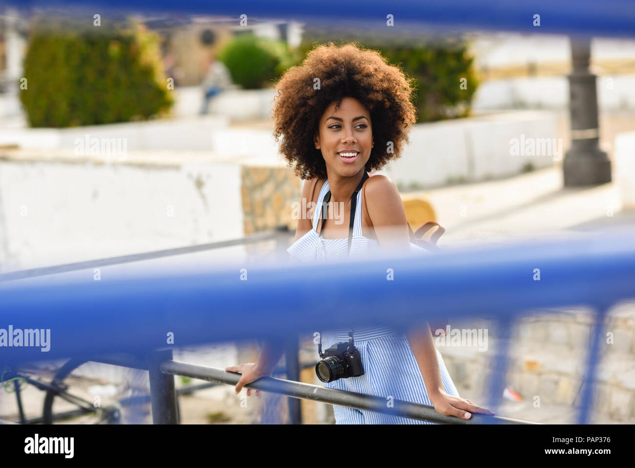 Portrait von lächelnden jungen Frau mit lockigem Haar auf einer Brücke Stockfoto
