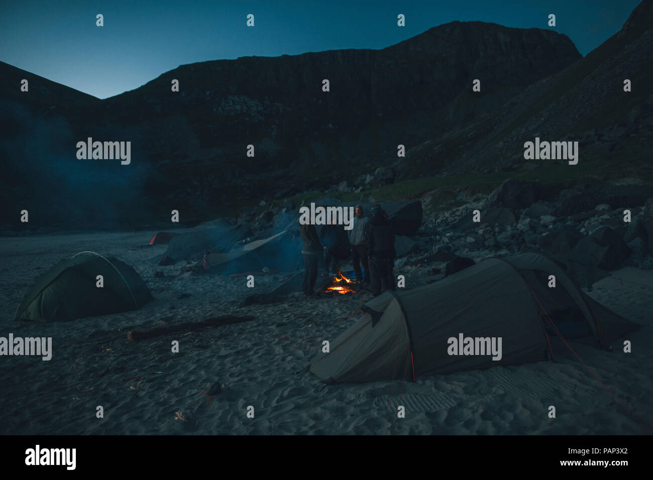 Norwegen, Lofoten, Moskensoy, Gruppe og junge Männer am Lagerfeuer am Strand von kvalvika Stockfoto