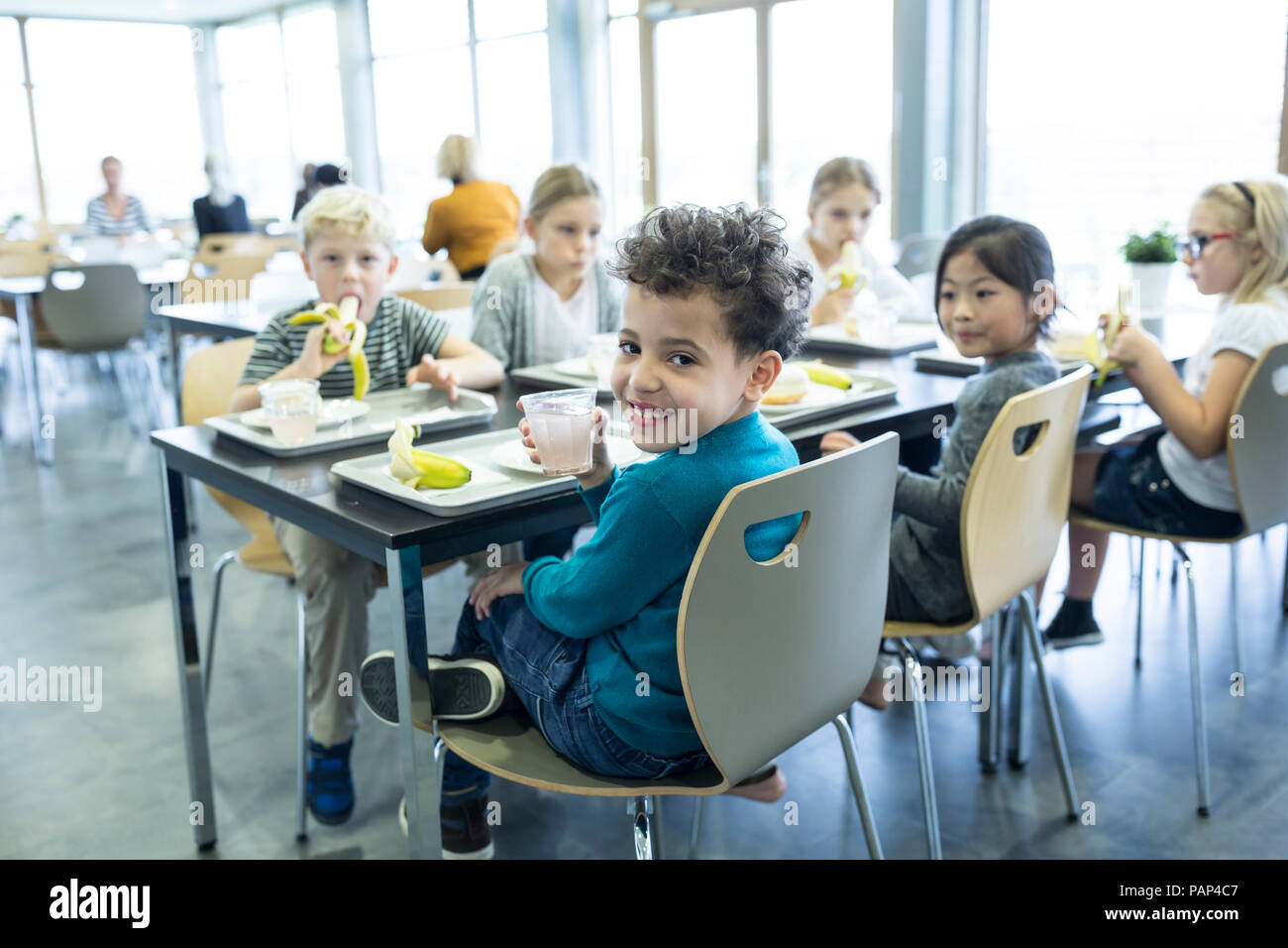 Schüler mit Mittagessen in der Schulkantine Stockfoto