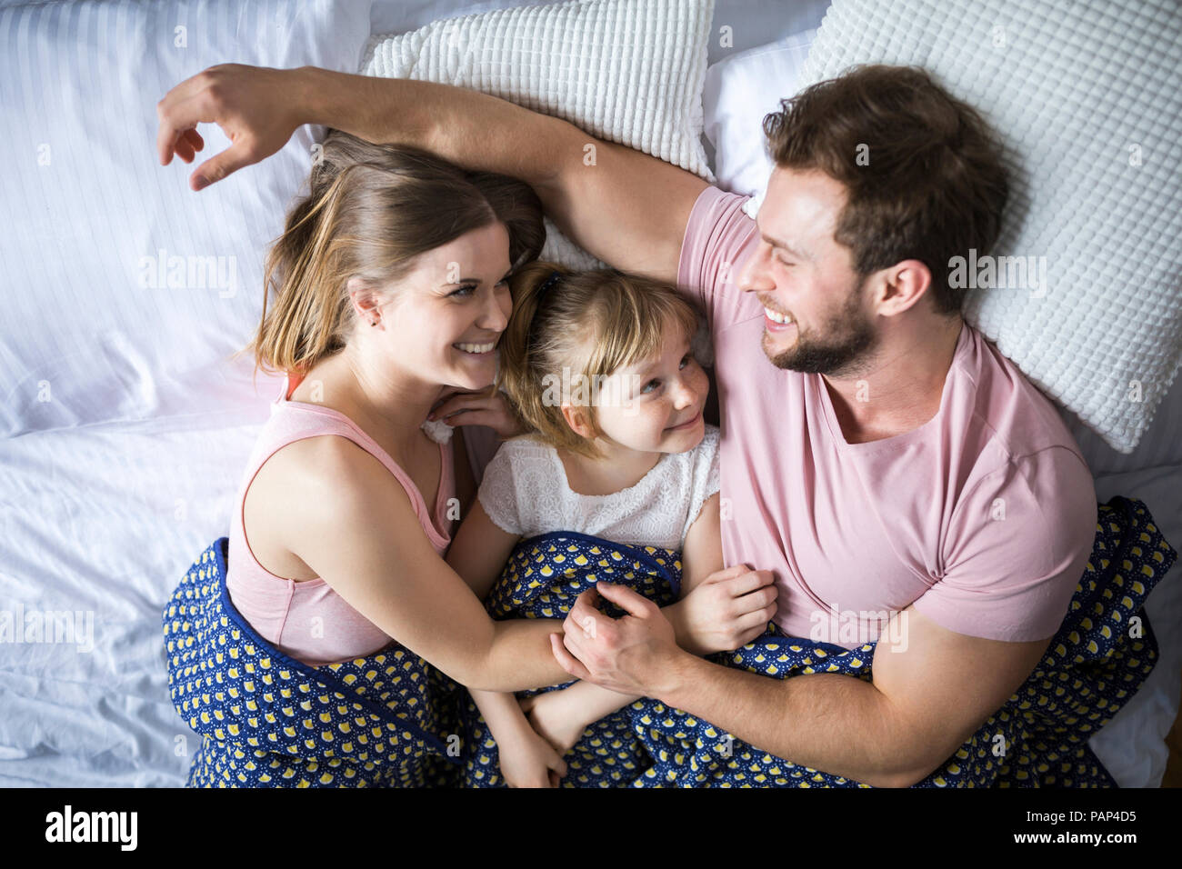 Happy Family im Bett liegen, kuscheln Stockfoto