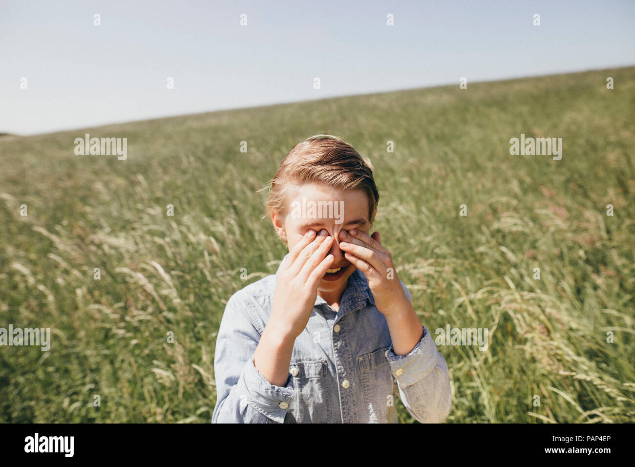 Junge auf einem Feld rieb seine Augen Stockfoto