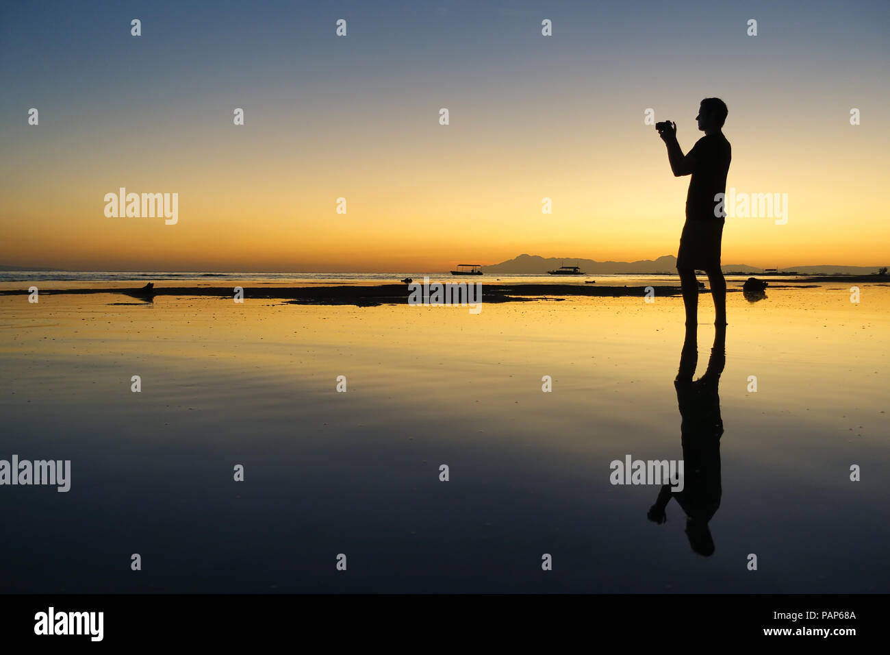 Profil von touristischen Mann Fotos auf der Insel Strand während der schönen orange Sonnenuntergang - Panglao, Bohol, Philippinen Stockfoto