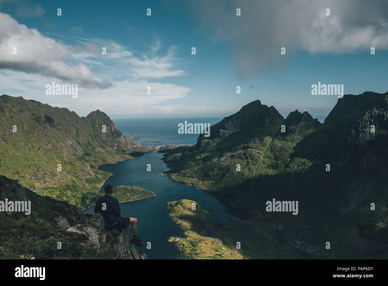 Norwegen, Lofoten, Traveller sitzt auf Felsen, mit Blick über den See Agvatnet Stockfoto