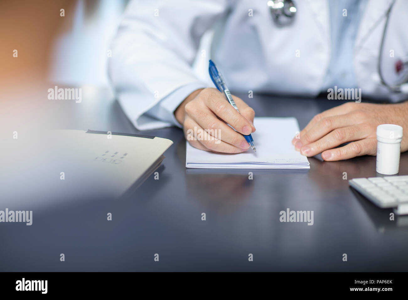 Arzt an seinem Schreibtisch sitzen Notizen Stockfoto
