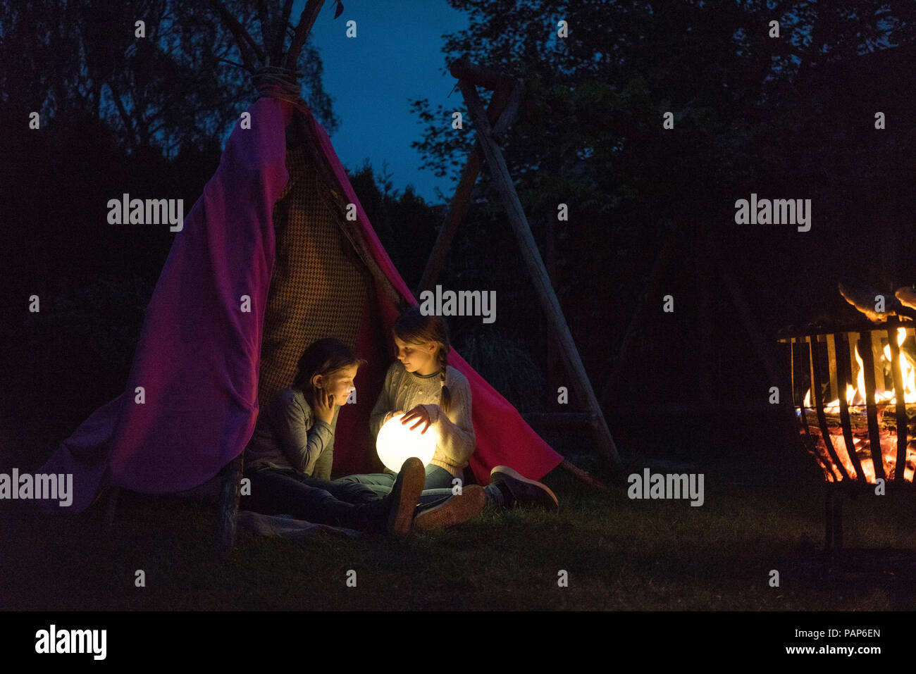 Zwei Mädchen sitzen im Tipi, Lampe wie Mond Stockfoto