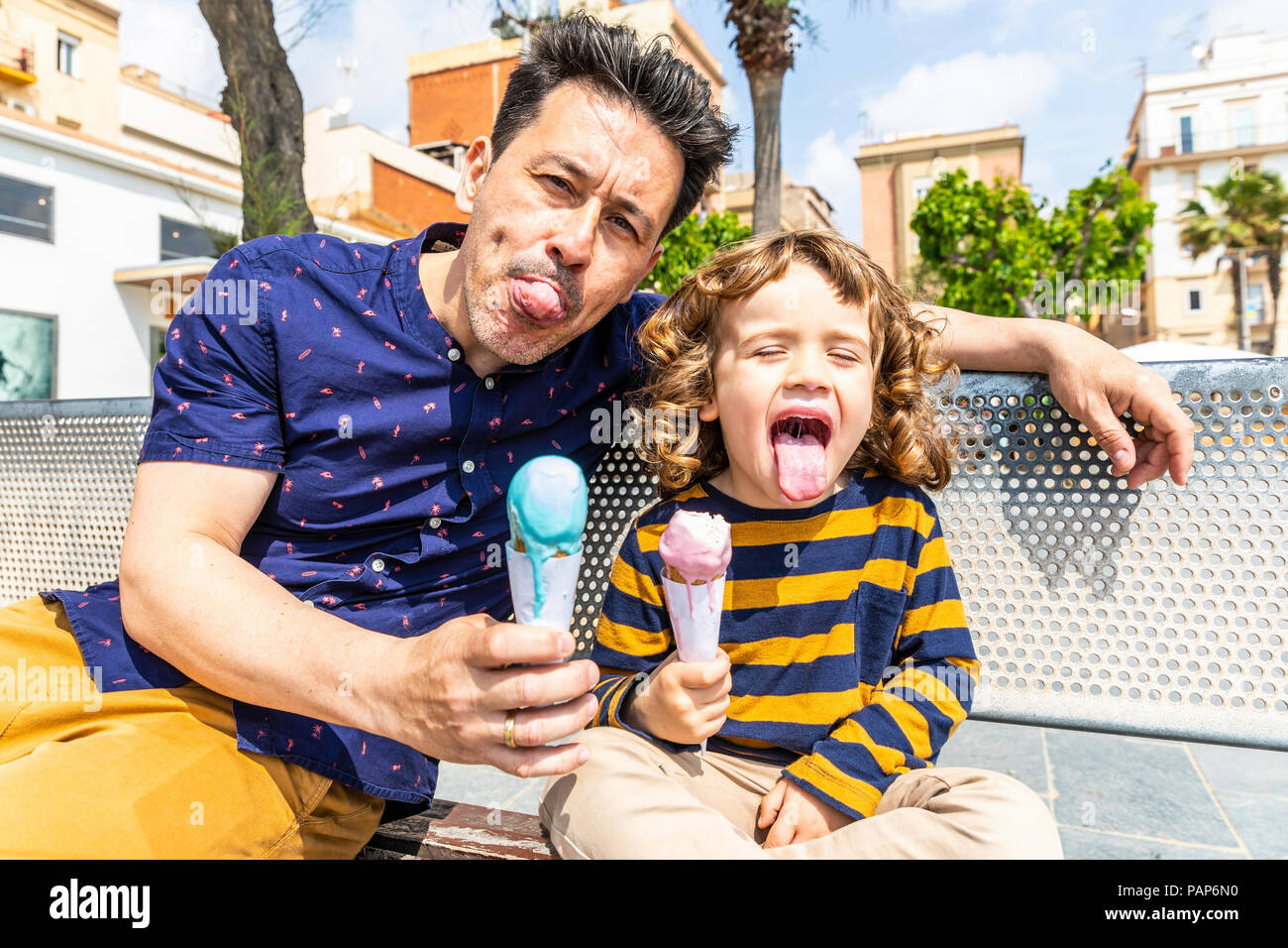 Spanien, Barcelona, gerne Vater und Sohn sitzt auf der Bank ein Eis genießen. Stockfoto