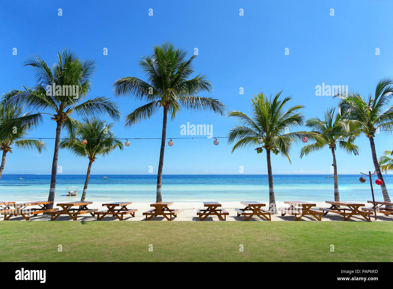 Perfekte White Sand Beach mit Picknicktischen, Palmen und Outdoor Resort - Panglao, Bohol, Philippinen Stockfoto