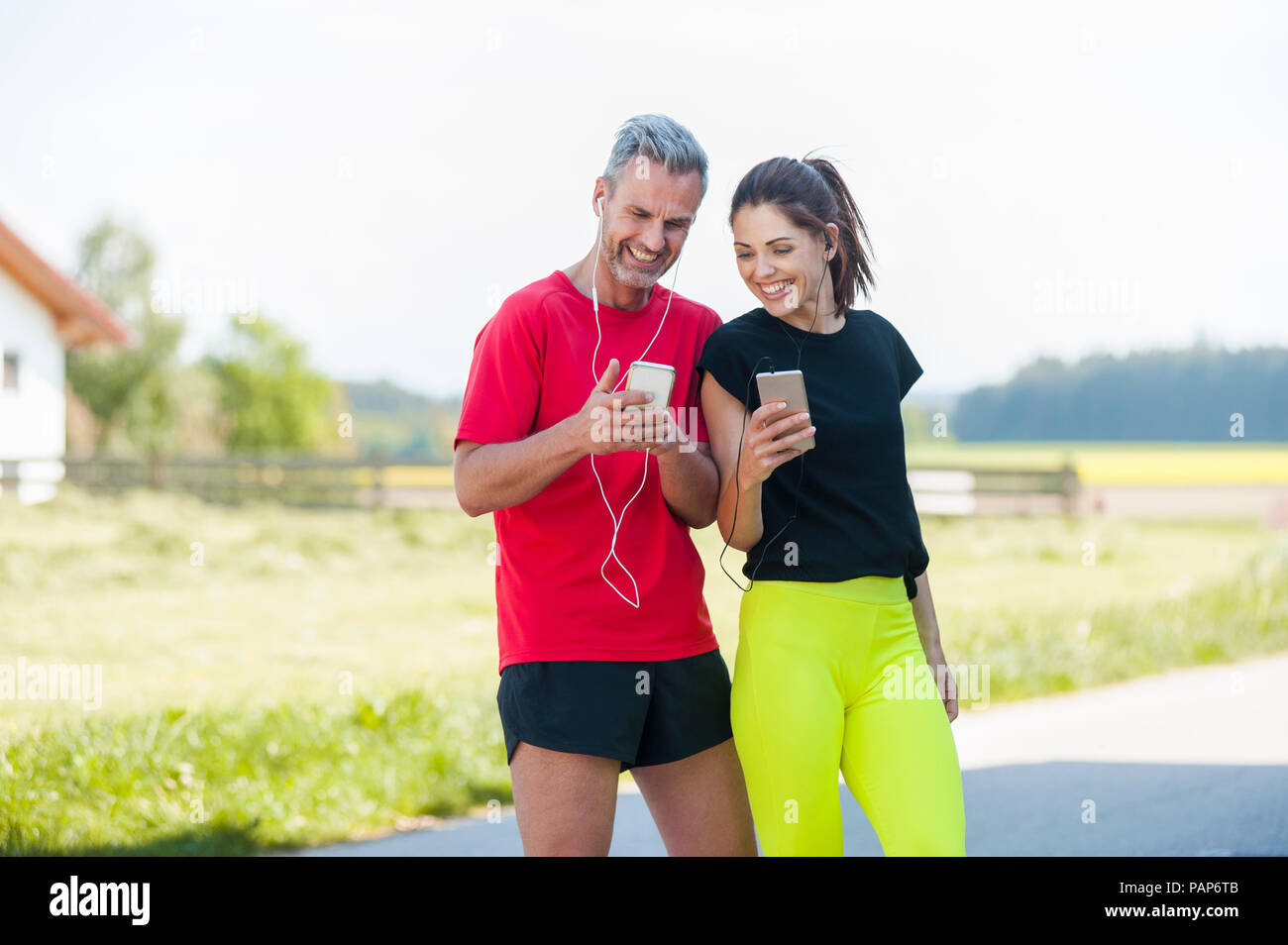 Paar mit Smartphones während des Trainings Stockfoto