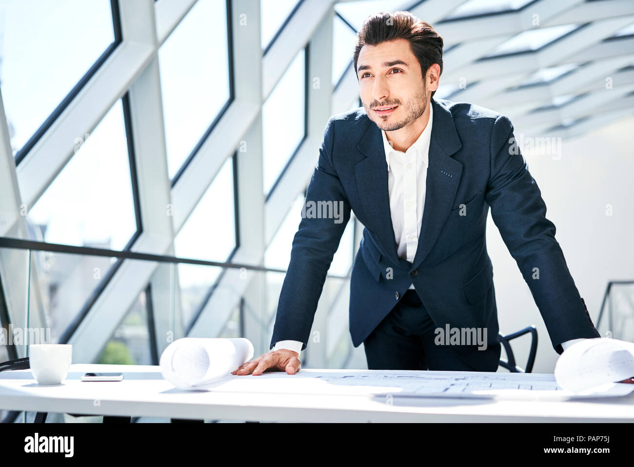 Unternehmer stehen am Schreibtisch mit Plan im Büro Stockfoto