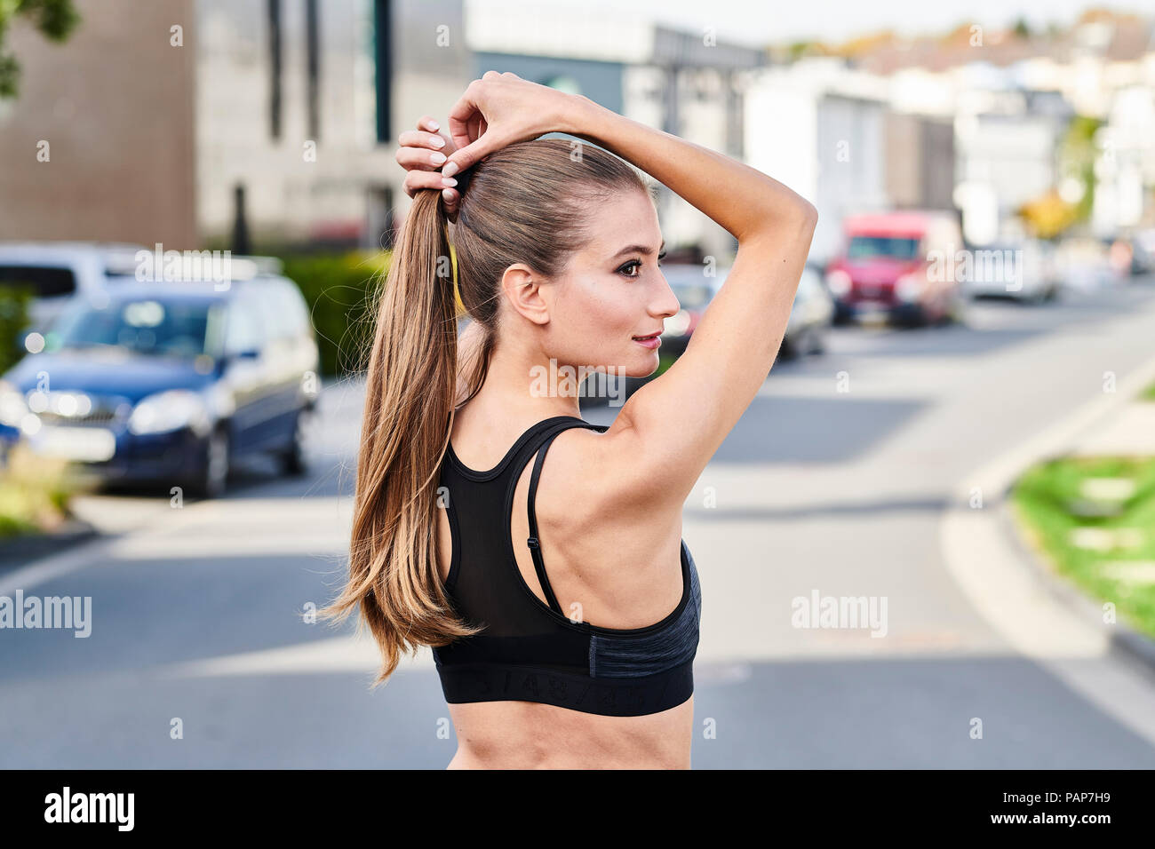 Attraktive sportliche junge Frau auf einer Straße in der Stadt Stockfoto
