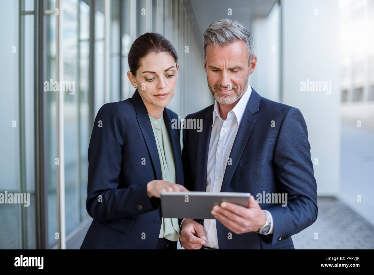 Porträt von zwei Geschäftspartnern zusammen an Tablet suchen Stockfoto