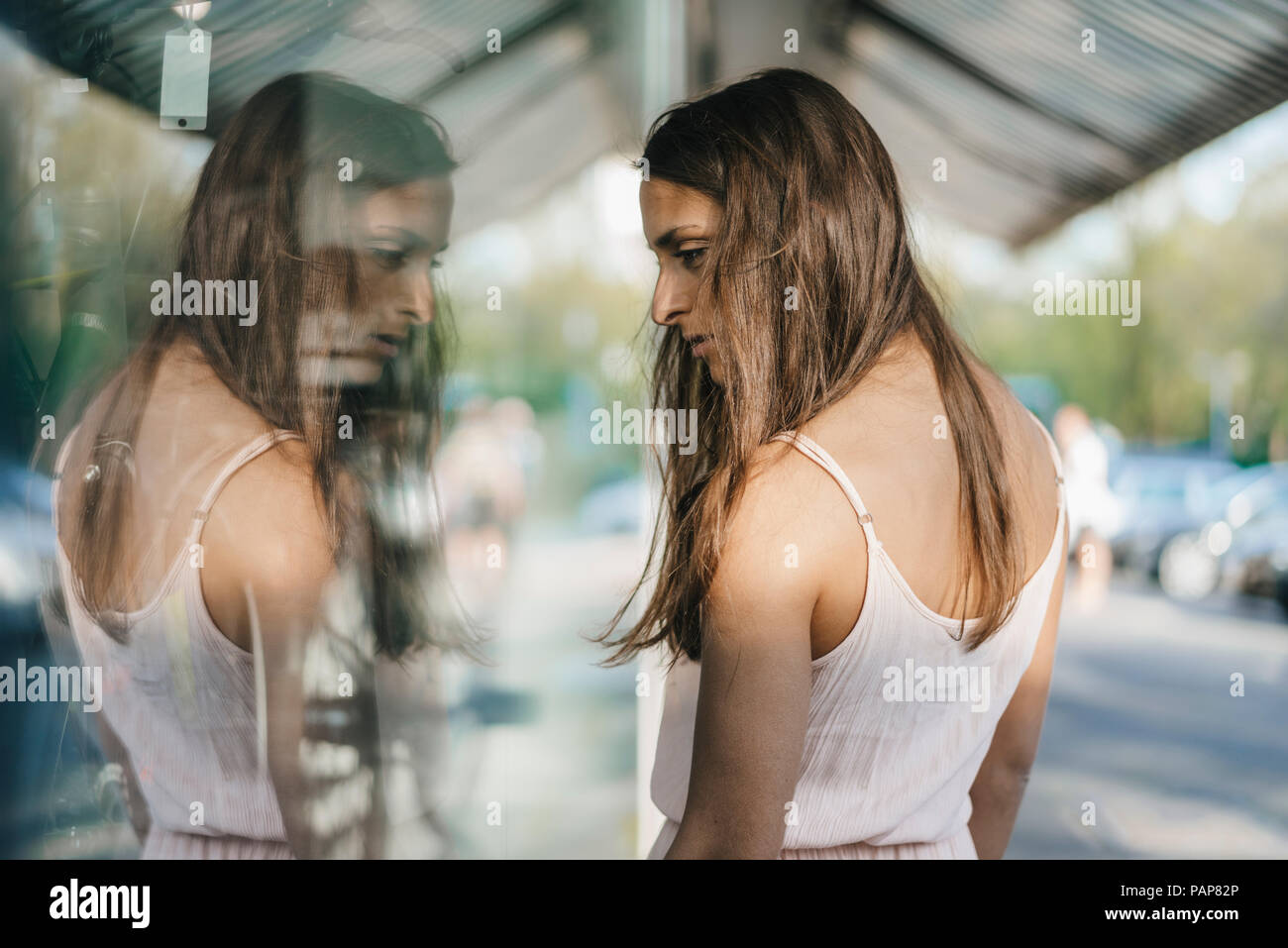 Hübsche junge Frau Fenster Shopping in der Stadt Stockfoto