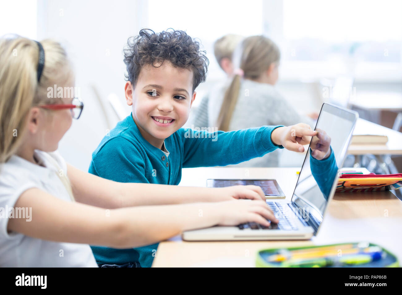 Schüler und Schülerin mit Laptop zusammen in der Klasse Stockfoto