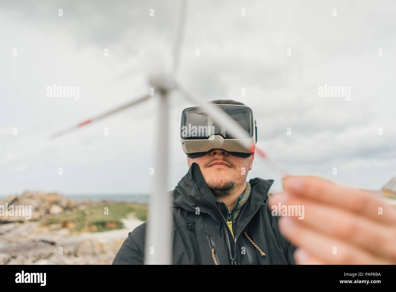 Frankreich, Bretagne, Meneham, Mann mit Miniatur wind turbine ...