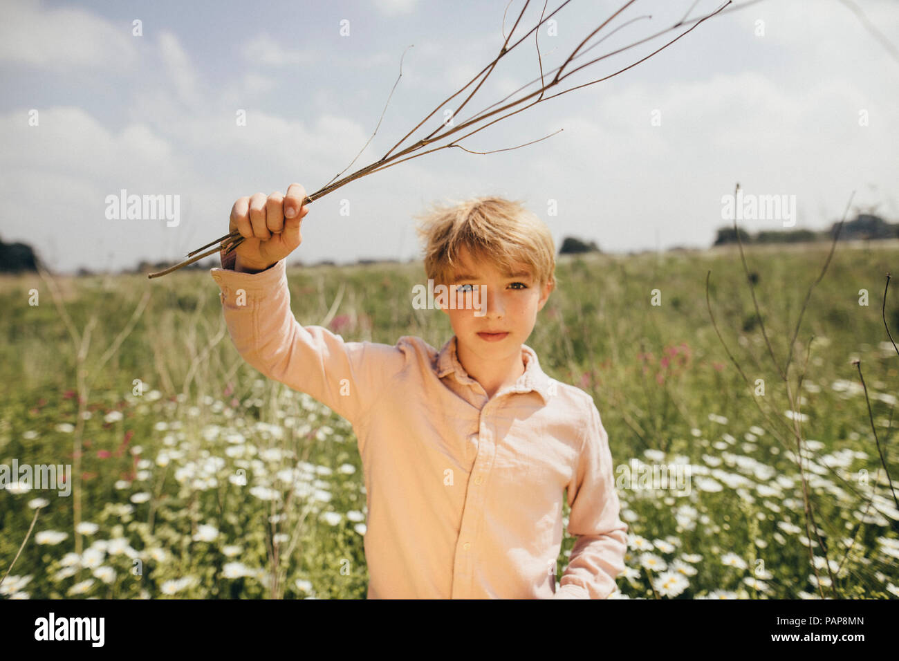 Porträt der blonde Junge mit Zweigen in der Natur Stockfoto