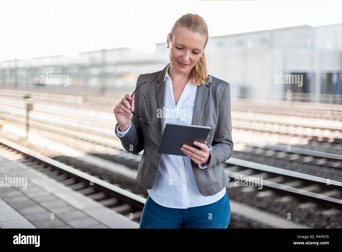 Reife Geschäftsfrau mit Tablet Plattform warten Stockfoto