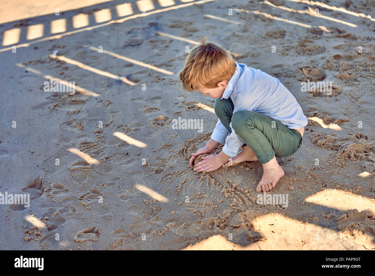 Jungen spielen im Sand am Strand Stockfoto