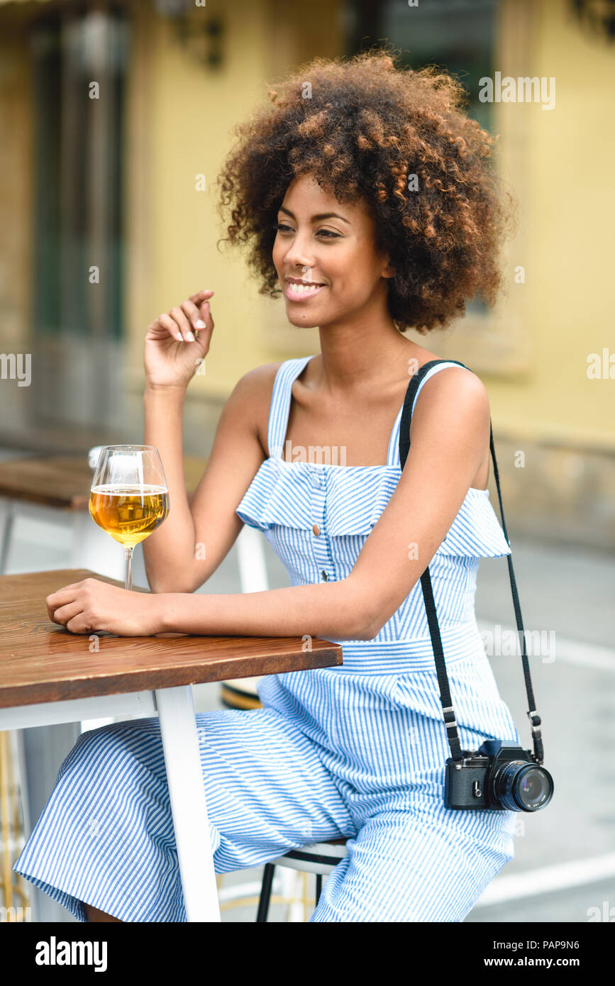 Portrait von modische junge Frau mit Kamera draußen Bier trinken. Stockfoto