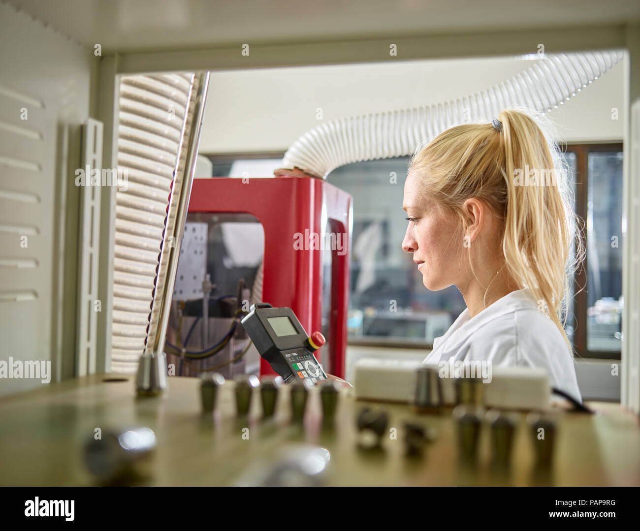 Technikerin Aufrechterhaltung der CNC-Maschine Stockfoto