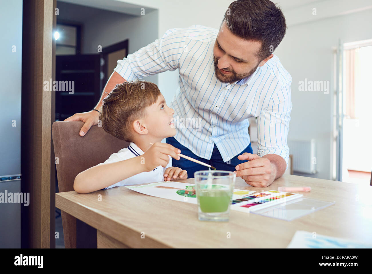 Vater und Sohn Farbe auf das Papier an den Tisch. Stockfoto