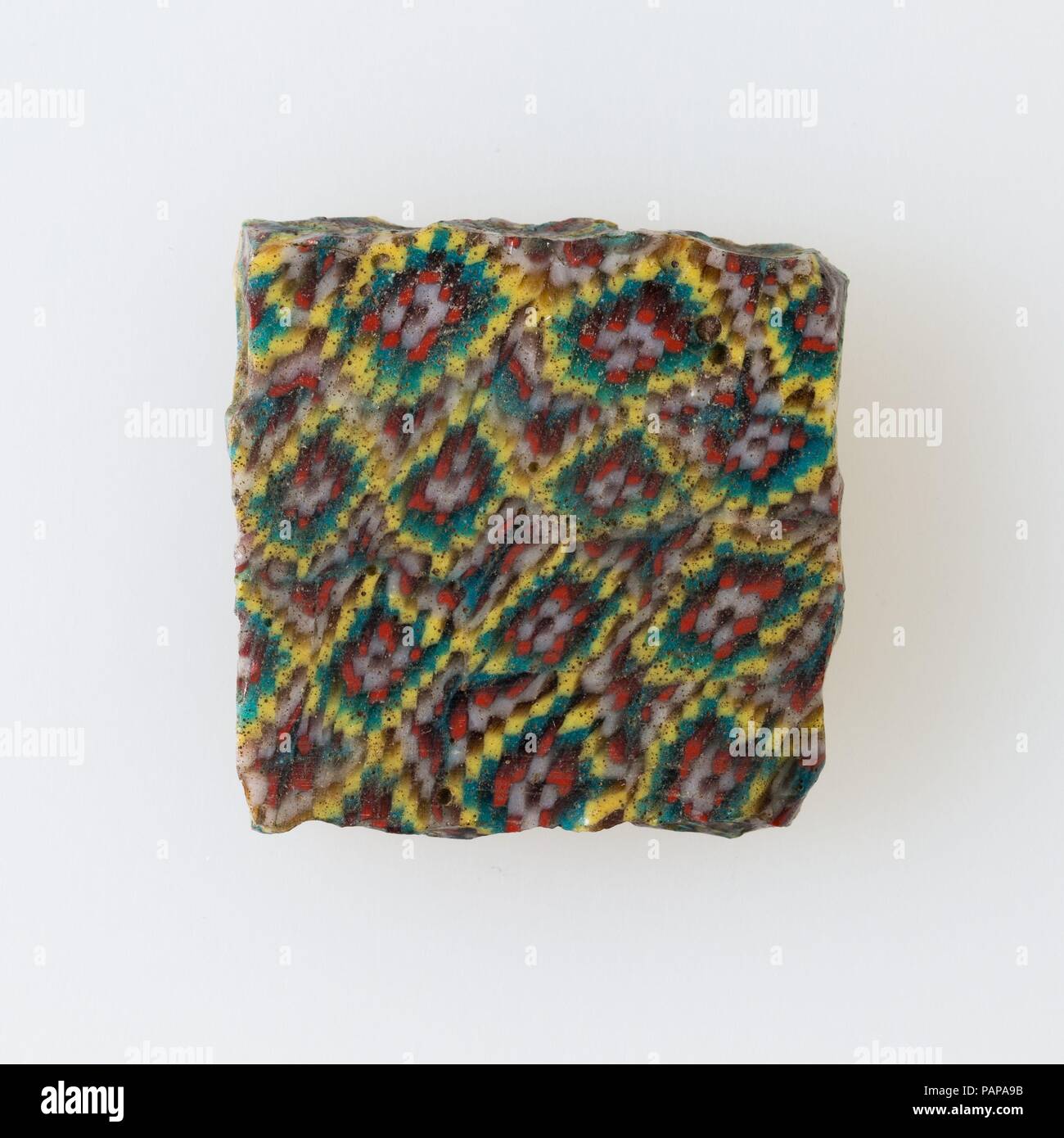 Inlay Fragment, Netzwerk Muster mit Zentren. Abmessungen: H.3 × W. 3 cm (1 3/16 x 1 3/16 in.). Datum: 100BC-100AD. Ein Mosaik aus Glas Technik erlaubt Vielfache von einem Bild erstellt werden: Ein figürlicher oder Design Komposition wurde durch die Bündelung von farbigem Glas Stöcke, die dann in eine lange Bar gezogen wurden. Die Bar war dann im rechten Winkel geschnitten, wahrscheinlich, indem die Bar mit entsprechenden Tools, kleine inlay Fliesen zu produzieren. Die Kachel wird dann geglättet werden und auf dem Gesicht erscheinen soll nach außen poliert. Museum: Metropolitan Museum of Art, New York, USA. Stockfoto