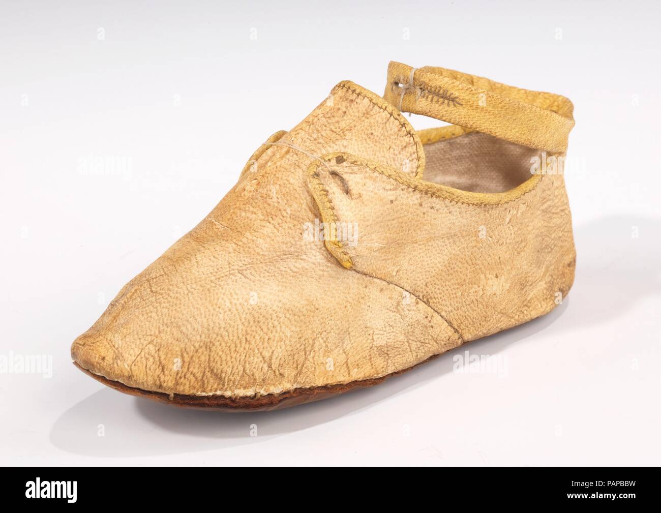 Schuhe. Kultur: Wahrscheinlich Europäische. Datum: 1775-1825. Eines der wenigen Beispiele des 18. Jahrhunderts von Kinderschuhen in der Sammlung erhalten, dieses Kind Schuh verfügt über eine ansprechende zweifarbige gelben Farbschema Interesse für die einfache Form hinzuzufügen. Der Schnitt ergibt sich aus dem nach schuhriemen-tie-Stil, sondern hat den zusätzlichen Feature einer Knoechelriemchen. Obwohl kein Merkmal von Erwachsenen Schuhe zu der Zeit, Riemchen auf Kinderschuhe gemeinsam sind, wie Sie sicher der Schuh sicherer zu zappelnde Füße. Museum: Metropolitan Museum of Art, New York, USA. Stockfoto