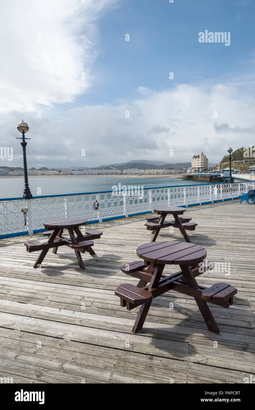 Picknick Bänke auf dem schönen alten Pier in Llandudno, North Wales. Blick zurück Richtung Strand und Hotels. Stockfoto