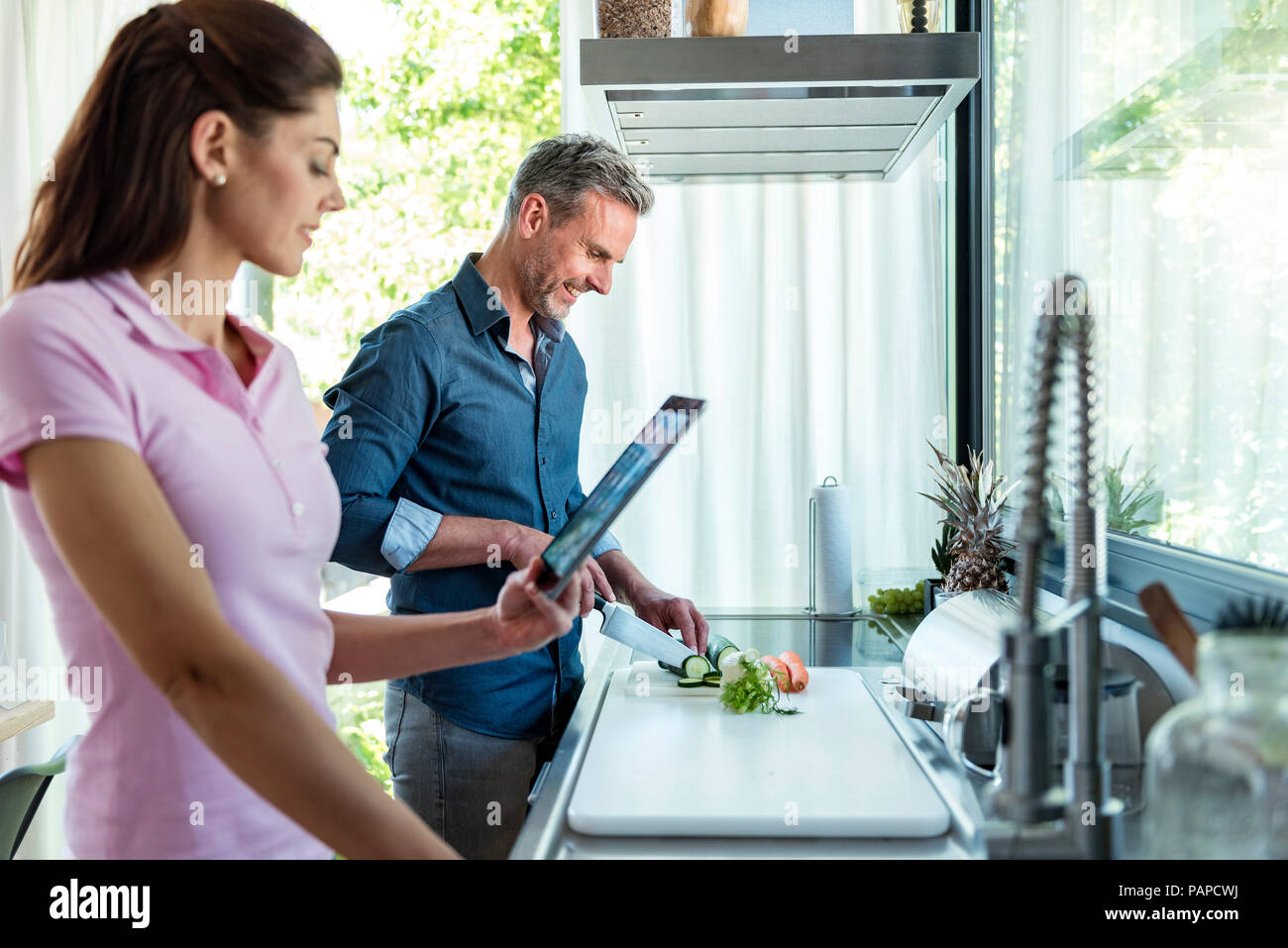 Paar in der Küche zu Hause kochen und mit einem Tablet Stockfoto