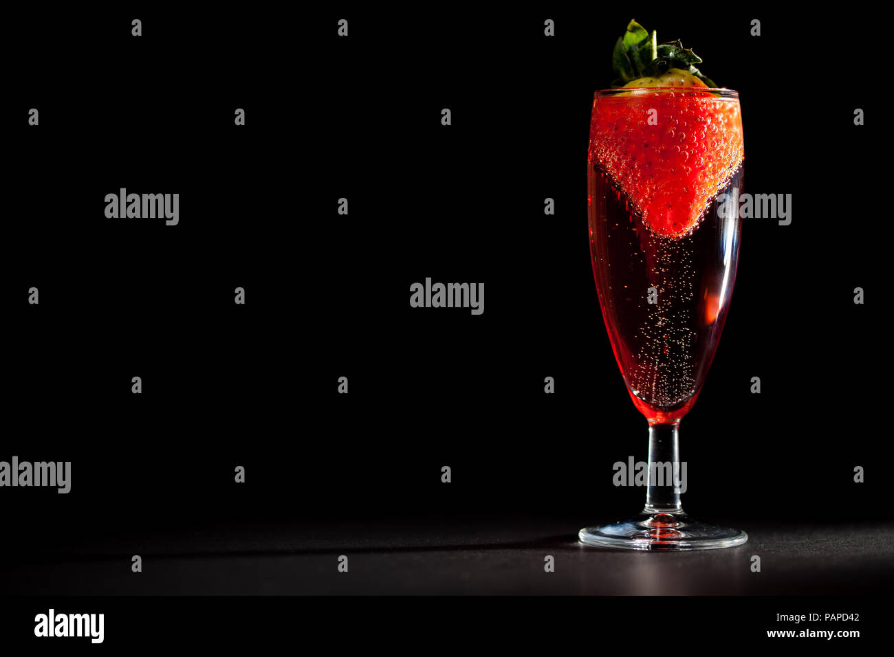 Feier trinken. Glas prickelnden Champagner Rosé Wein mit Erdbeere. Perfekte Valentinstag oder Geburtstag Nachsicht. Schwarzer Hintergrund mit Kopie sp Stockfoto