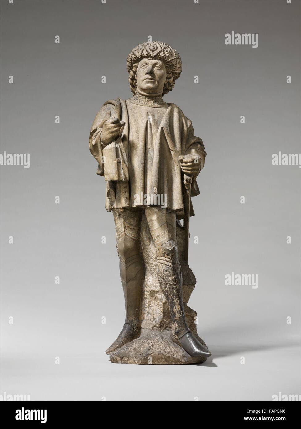 Saint Bavo. Kultur: Norden Niederländischen. Abmessungen: Insgesamt: 44 1/4 x 17 x 14 cm. (112,4 x 43,2 x 36,2 cm). Datum: Ca. 1460. Saint Bavo (d. 657), der Schutzheiligen von Gent und Haarlem, wird teilweise durch seine Rüstung, Schwert und reichen Kleidung, die seine aristokratischen Status anzeigen. Die "Book bag' in seiner rechten Hand ist ein beliebter spätmittelalterlichen Zubehör. Museum: Metropolitan Museum of Art, New York, USA. Stockfoto