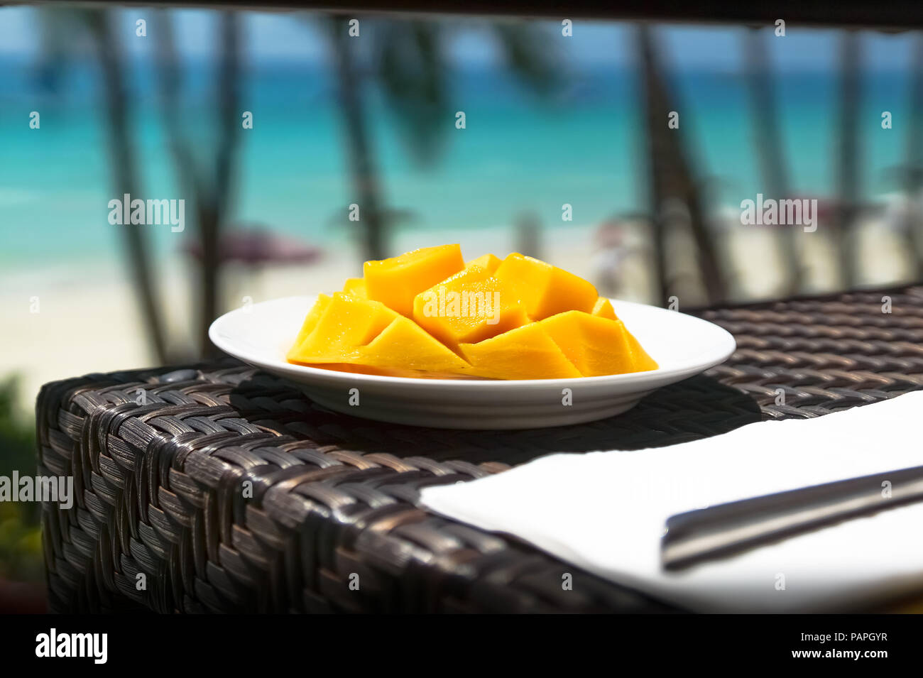 Frisch geschnittene Mango auf einer Platte im Restaurant, mit Tropischen türkisfarbene Meer Landschaft - White Beach, Boracay - Philippinen Stockfoto
