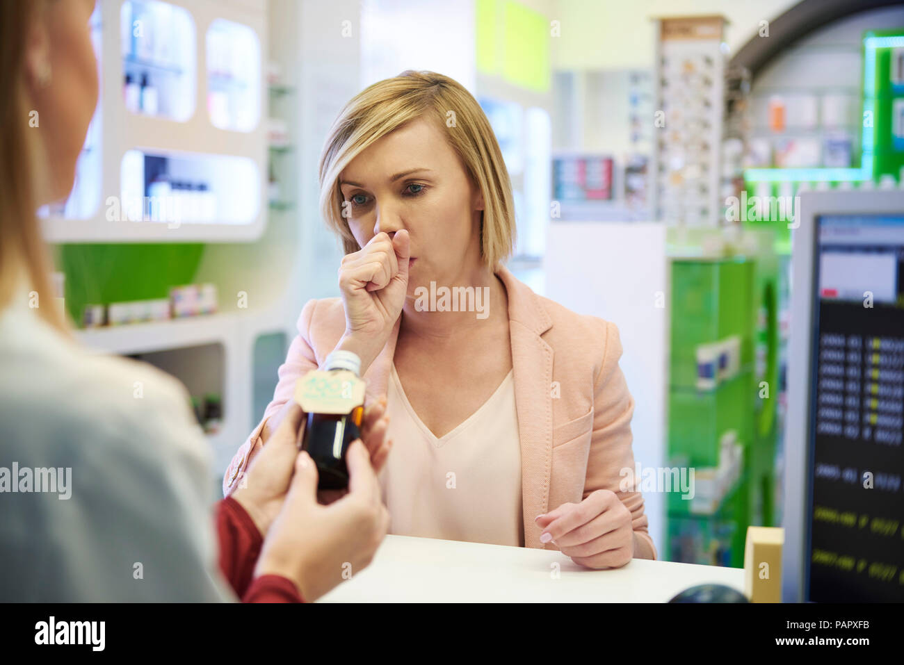 Apotheker verkaufen hustensirup zur Frau in der Pharmazie Stockfoto