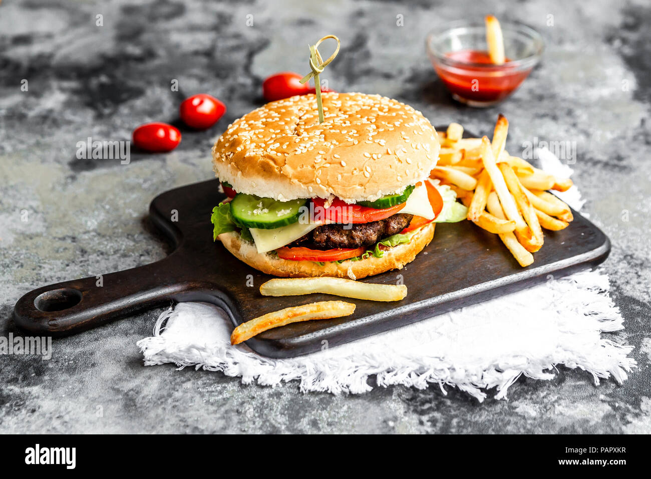 Hausgemachte Hamburger mit Käse, Pommes frites, Ketchup und Tomatenmark Stockfoto