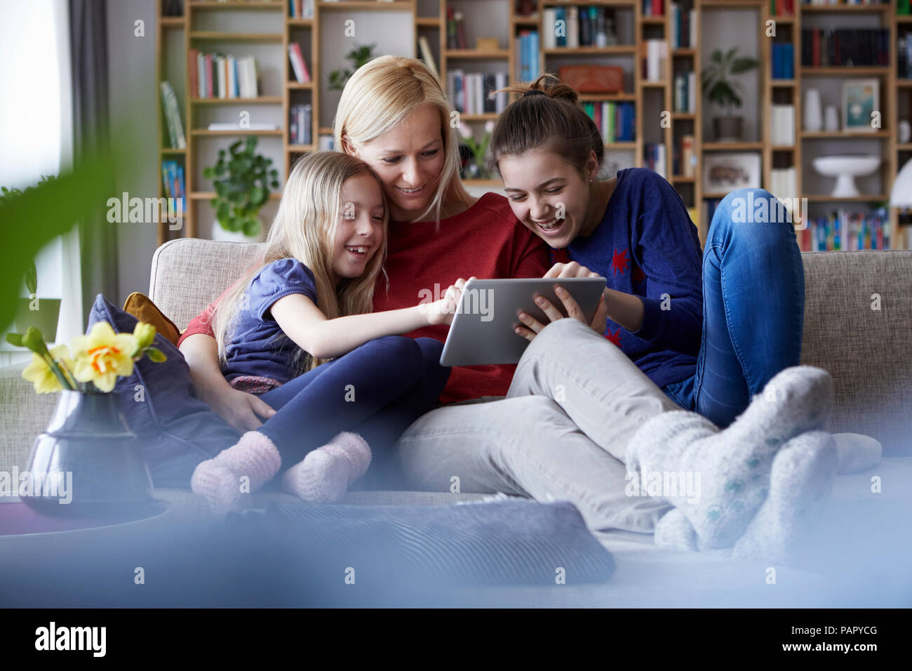 Mutter und ihre Töchter auf der Couch sitzen, Spaß mit digitalen Laptop Stockfoto