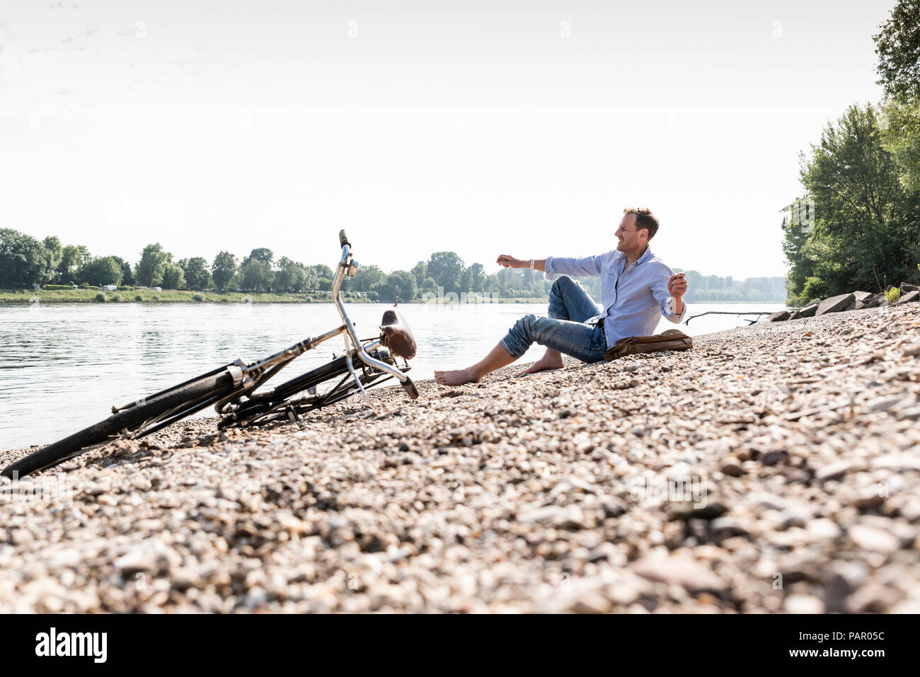 Reifer Mann mit Fahrrad an Rhein Ufer Stockfoto