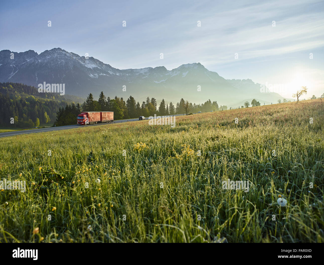Österreich, Tirol, Lkw auf Landstraße im Morgenlicht Stockfoto